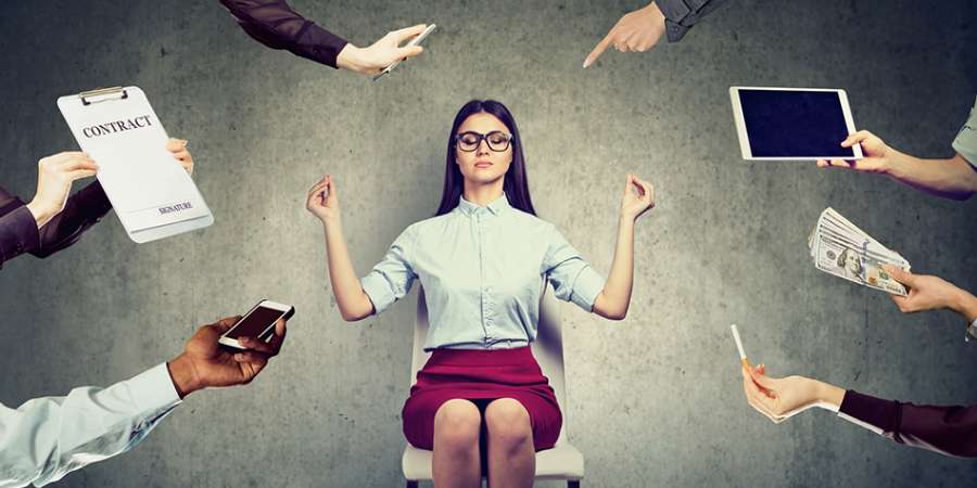 Woman meditating while surrounded by tasks
