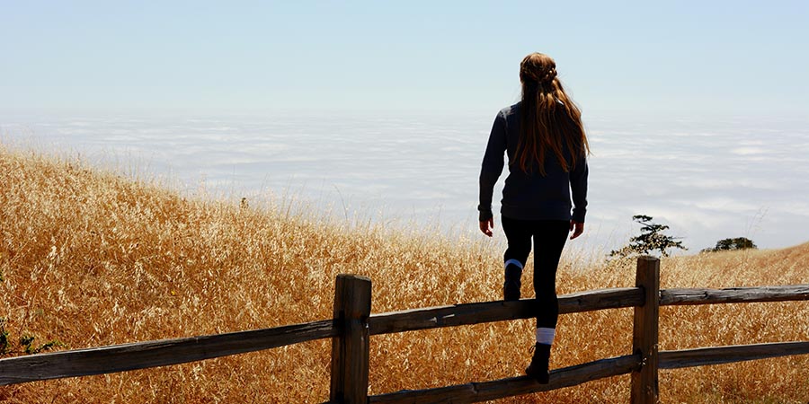 Woman walking over fence