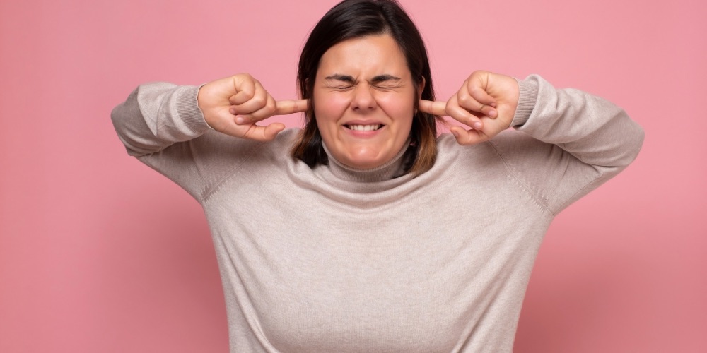 Avoiding conflict, woman with fingers in ears